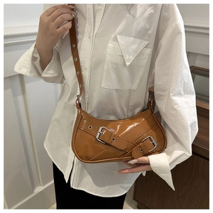Detail view of caramel faux leather bag featuring dual metal buckles and stitch texture