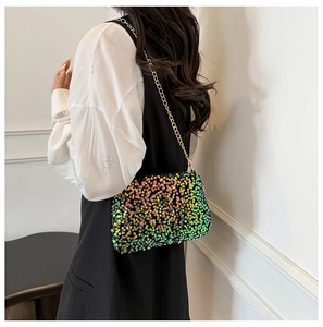 Détail d'un sac bandoulière à paillettes colorées avec chaîne dorée porté par un mannequin
