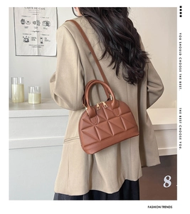 Detail of brown quilted shell bag featuring geometric stitching and dual metal zippers