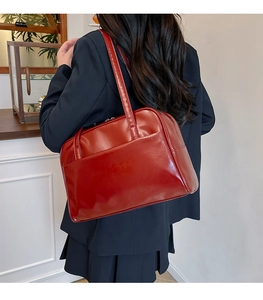 Model wearing a retro deep red faux leather tote bag with a polished glossy finish