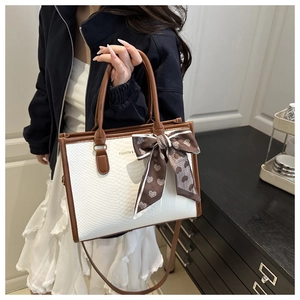 Chic white croc-embossed tote bag with dark brown trim and decorative silk scarf detail