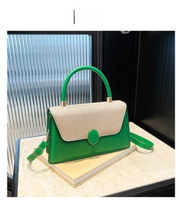 Detail of green leather and beige canvas handbag with gold hardware on vintage book
