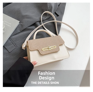Détail du sac à main avec rabat contrasté, fermoir chaîne doré et texture premium