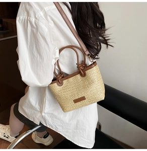 Détail du sac à main en paille tressée avec bordure en cuir marron et bandoulière