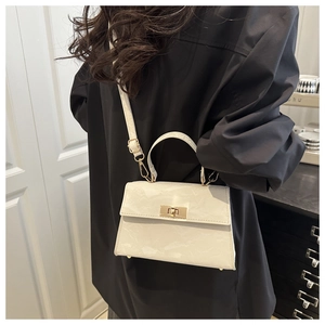 Detailed view of white marble texture handbag with gold metal lock and leather strap