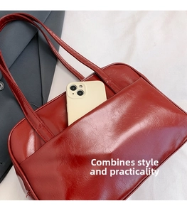Detail of dark red glossy tote bag featuring a practical front pocket for smartphone storage