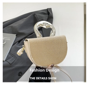 Détail du sac bandoulière avec poignée argentée et texture cuir beige et paille