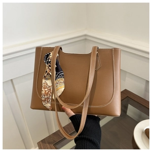 Détail d'un grand sac cabas en cuir marron avec surpiqûres blanches et foulard noué