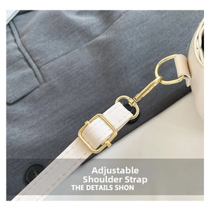 Détail d'une bandoulière beige réglable avec des ferrures en métal doré