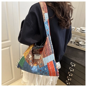 Detail view of the colorful patchwork fabric and drawstring closure on the shoulder tote bag