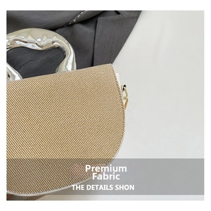 Détail du tissu tissé et de la poignée en métal argenté liquide sur un sac bandoulière chic