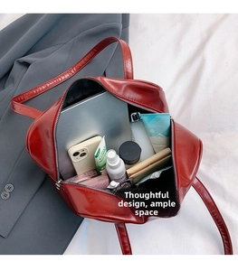 Macro view showing spacious interior of red leather tote bag with various accessories