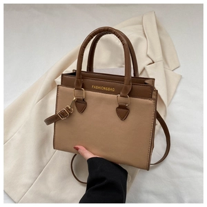Detail view of the brown and khaki contrast leather handbag with golden fashion lettering