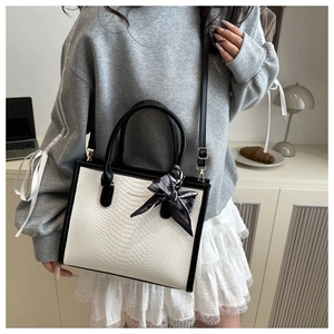 Detailed view of black and white snakeskin pattern tote with printed silk scarf handle