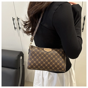 Dettaglio di una borsa a tracolla trapuntata marrone con stampa floreale e logo in pelle