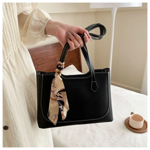 Détail du sac cabas noir avec surpiqûres blanches et foulard en soie décoratif