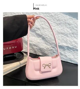 Detail of pink vintage underarm bag with a golden bow buckle and smooth PU leather