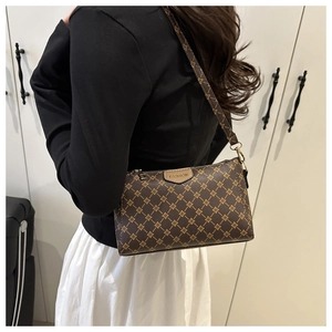 Dettaglio borsa a tracolla marrone vintage con motivo floreale e catena dorata