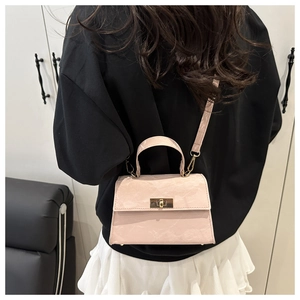 Pink marble texture crossbody bag with gold twist lock shown on model for size reference