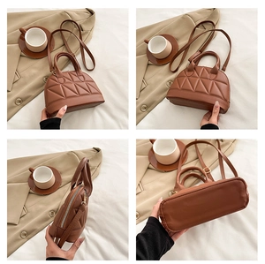 Detail of caramel quilted shell bag with dual handles and adjustable shoulder strap