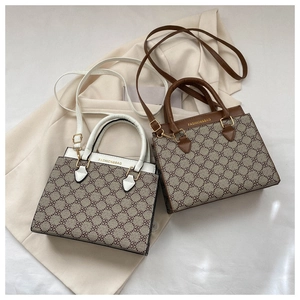 Flat lay of vintage monogram tote bags in brown and white PU leather on beige blazer