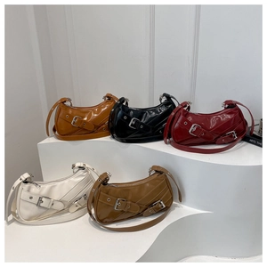 Detail view of five crescent shoulder bags in multiple colors with metallic buckle straps