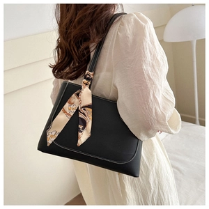Détail d'un sac cabas noir avec surpiqûres blanches contrastées et foulard en soie décoratif
