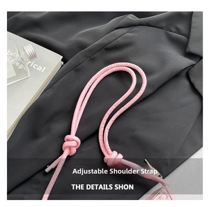Detail of adjustable pink leather shoulder strap with knotted design and silver metal tips