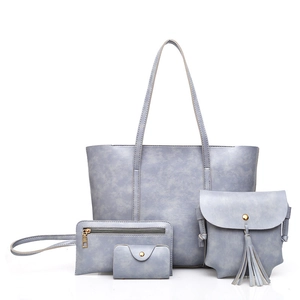 Four-piece vintage faux leather bag set in dusty blue featuring tote, crossbody and clutch