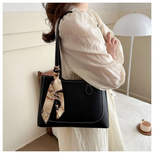 Détail du sac cabas noir minimaliste avec surpiqûres blanches et accessoire foulard en soie