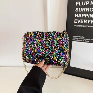 Sac bandoulière à paillettes colorées avec chaîne dorée présenté à la main