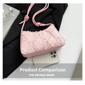 Pink denim underarm bag size comparison with a smartphone showing dimensions and frayed texture