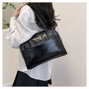 Detail of black faux leather tote with vintage oil texture and large front pocket