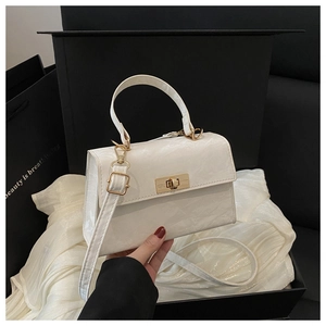 Detail view of cream crossbody bag with marble texture and golden twist lock closure