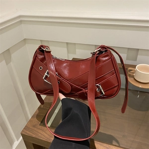Deep red crescent underarm bag with decorative belt buckles in polished PU leather finish