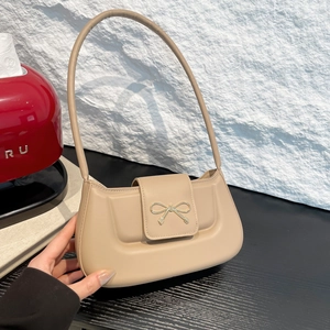 Minimalist beige shoulder bag with metal bow detail and sleek faux leather finish