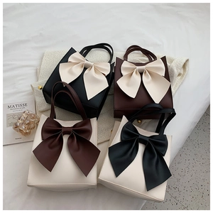 Flat lay of high-capacity tote bags with large bow accents in four color combinations