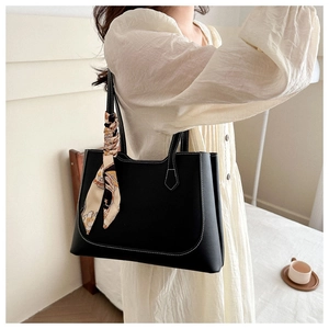 Détail du sac fourre-tout noir avec surpiqûres blanches et foulard imprimé décoratif