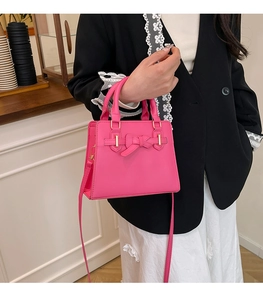 Détail du nœud fuchsia et des ferrures dorées sur un sac à bandoulière élégant