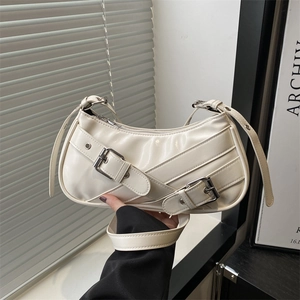Minimalist cream crescent underarm bag with decorative belt buckles and silver hardware