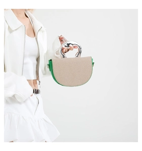 Détail du sac en cuir vert avec texture tissée et poignée en métal argenté fluide