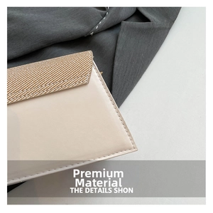 Detail van beige leer en geweven textuur met nauwkeurige witte stiksels op de tas