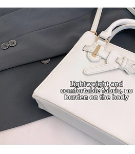 Gros plan d'un sac à main blanc en cuir avec boucle dorée et détail de nœud élégant