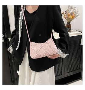 Detailed close-up of pink crescent bag showing quilted denim texture and fringe edges