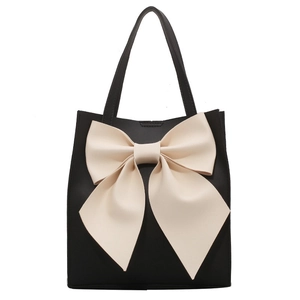 Elegant black tote bag for women featuring a large cream white decorative bow detail
