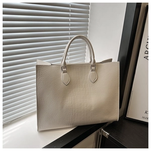Détail de la texture motif crocodile blanc sur un grand sac cabas au style minimaliste