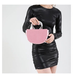 Gros plan d'un sac à main rose demi-lune avec une poignée argentée en forme de cœur