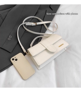Detailed comparison showing the cream rectangular handbag size relative to a smartphone