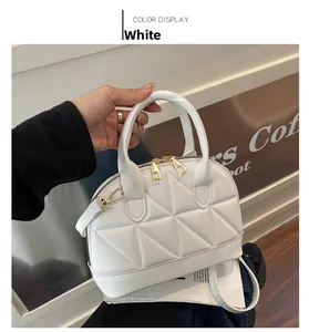 White shell-shaped handbag featuring triangular geometric quilting and golden hardware