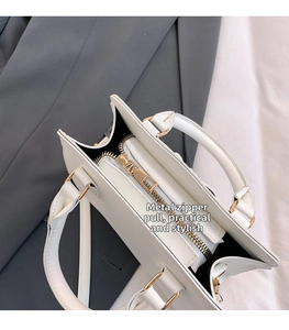 Détail de l'intérieur du sac blanc montrant la fermeture dorée et les compartiments